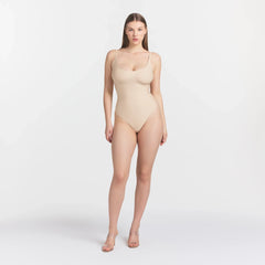 SKIMS BODY SCOOP LOW BACK THONG BODYSUIT | SAND ON A MODEL FRONT VIEW @