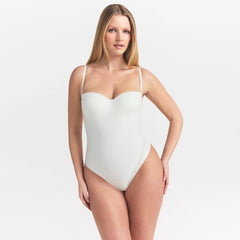 SKIMS BODY UNDERWIRE THONG BODYSUIT | IVORY ON A MODEL SIDE VIEW @