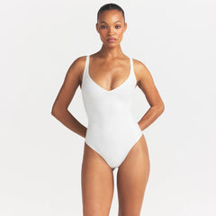 SKIMS BODY UNLINED PLUNGE THONG BODYSUIT | IVORY ON A MODEL SIDE VIEW @