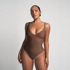 SKIMS BODY UNLINED PLUNGE THONG BODYSUIT | JASPER ON A MODEL FRONT VIEW @