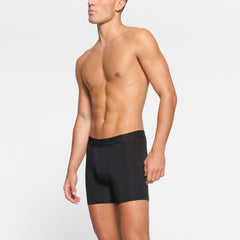 SKIMS STRETCH MENS 5" BOXER BRIEF 3-PACK WORN BY A MODEL IN SIDE VIEW