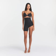 SKIMS BODY LEFT LEG SOLUTION SHORT | ONYX ON A MODEL FRONT VIEW @