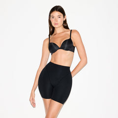 SKIMS BODY BUTT AND HIP ENHANCING MID THIGH SHORT | ONYX ON A MODEL SIDE VIEW @ | FOCUS: 0.0, 1.0, 0.9