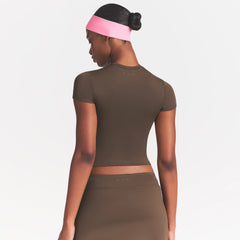NikeSKIMS MATTE PADDED BABY TEE | DARK SEPIA ON A MODEL FRONT VIEW @ | FOCUS: 0.0, 1.0, 0.9