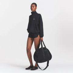 NikeSKIMS ACCESSORIES PUFFER GYM BAG | OBSIDIAN ON A MODEL FRONT VIEW @ | FOCUS: 0.0, 1.0, 0.9