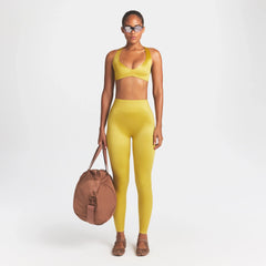 NikeSKIMS SATIN SHINE BONDED WAIST 26" LEGGING | CITRINE ON A MODEL FRONT VIEW @ | FOCUS: 0.0, 1.0, 0.9