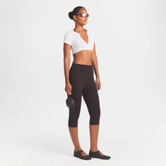 NikeSKIMS STUDIO STRETCH 17" CAPRI LEGGING | DARK ROAST/(NSKMDR) ON A MODEL FRONT VIEW @ | FOCUS: 0.0, 1.0, 0.9