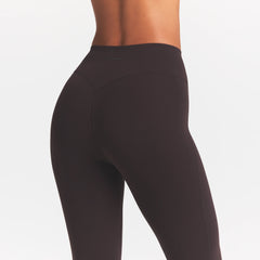 NikeSKIMS STUDIO STRETCH 17" CAPRI LEGGING | DARK ROAST/(NSKMDR) ON A MODEL SIDE VIEW @ | FOCUS: 0.0, 1.0, 0.9