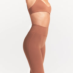 NikeSKIMS MATTE SLIM FLARE LEGGING | CAROB BROWN ON A MODEL SIDE VIEW @ | FOCUS: 0.0, 1.0, 0.9