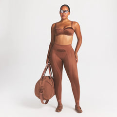 NikeSKIMS SATIN SHINE PANELED 26” LEGGING | CAROB BROWN ON A MODEL FRONT VIEW @ | FOCUS: 0.0, 1.0, 0.9