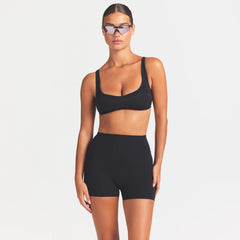 NikeSKIMS STUDIO STRETCH 3" SHORT | OBSIDIAN ON A MODEL SIDE VIEW @ | FOCUS: 0.0, 1.0, 0.9