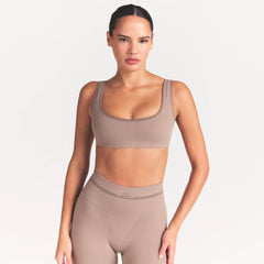 NikeSKIMS RIBBED SEAMLESS MICRO SCOOP BRA | DRIFTWOOD ON A MODEL SIDE VIEW @ | FOCUS: 0.0, 1.0, 0.9