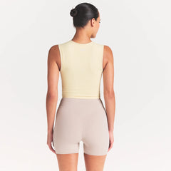 NikeSKIMS RIBBED SEAMLESS MUSCLE TANK | LEMON DROP ON A MODEL SIDE VIEW @ | FOCUS: 0.0, 1.0, 0.9