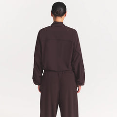 NikeSKIMS STRETCH NYLON OVERSIZED TRACK JACKET | DARK ROAST ON A MODEL SIDE VIEW @ | FOCUS: 0.0, 1.0, 0.9