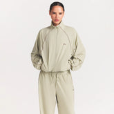 NikeSKIMS STRETCH NYLON OVERSIZED TRACK JACKET | TALC ON A MODEL SIDE VIEW @ | FOCUS: 0.0, 1.0, 0.9
