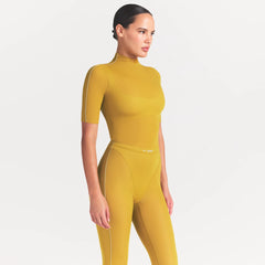 NikeSKIMS WEIGHTLESS LAYERS MOCK NECK SHORT SLEEVE T-SHIRT | CITRINE ON A MODEL FRONT VIEW @ | FOCUS: 0.0, 1.0, 0.9