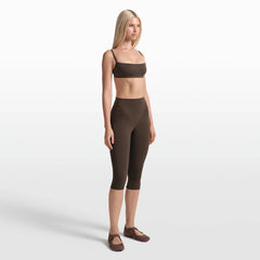NikeSKIMS MATTE 17" V-LINE CROP LEGGING | DARK SEPIA ON A MODEL FRONT VIEW @ | FOCUS: 0.0, 1.0, 0.9
