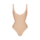 SKIMS BODY UNLINED PLUNGE THONG BODYSUIT | CLAY (SHAPEWEAR BODYSUITS, SHAPEWEAR) LAYS FLAT ON A WHITE BACKGROUND | FLT