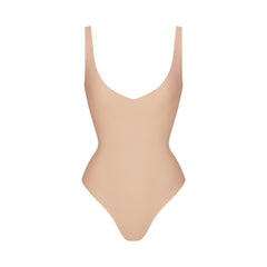 SKIMS BODY UNLINED PLUNGE THONG BODYSUIT | CLAY (SHAPEWEAR BODYSUITS, SHAPEWEAR) LAYS FLAT ON A WHITE BACKGROUND | FLT