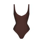 SKIMS BODY UNLINED PLUNGE THONG BODYSUIT | COCOA (SHAPEWEAR BODYSUITS, SHAPEWEAR) LAYS FLAT ON A WHITE BACKGROUND | FLT