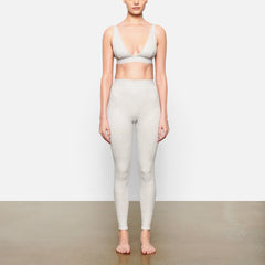 A MODEL STANDS FACING FORWARD WEARING THE COTTON RIB LEGGING | LIGHT HEATHER GREY