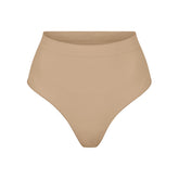 SEAMLESS SCULPT MID WAIST THONG | CLAY (SHAPEWEAR THONGS, PANTIES) LAYS FLAT ON A WHITE BACKGROUND | FLT