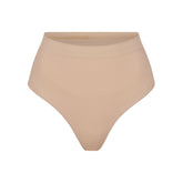 SEAMLESS SCULPT MID WAIST THONG | MICA (SHAPEWEAR THONGS, PANTIES) LAYS FLAT ON A WHITE BACKGROUND | FLT