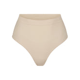 SEAMLESS SCULPT MID WAIST THONG | SAND (SHAPEWEAR THONGS, PANTIES) LAYS FLAT ON A WHITE BACKGROUND | FLT