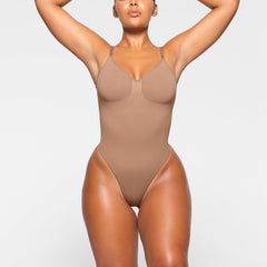 SEAMLESS SCULPT LOW BACK THONG BODYSUIT WORN BY A MODEL IN SIDE VIEW