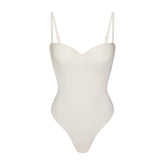 SKIMS BODY UNDERWIRE THONG BODYSUIT | IVORY FLAT ON A WHITE BACKGROUND | FLT