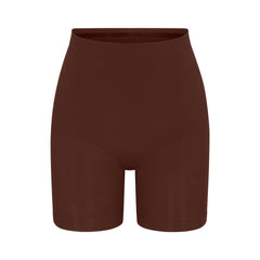 SEAMLESS SCULPT MID THIGH SHORT | COCOA (SHAPEWEAR SHORTS, SHAPEWEAR) LAYS FLAT ON A WHITE BACKGROUND | FLT