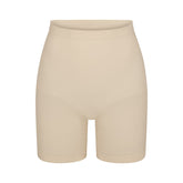 SEAMLESS SCULPT MID THIGH SHORT | SAND (SHAPEWEAR SHORTS, SHAPEWEAR) LAYS FLAT ON A WHITE BACKGROUND | FLT