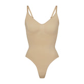 SEAMLESS SCULPT THONG BODYSUIT | CLAY (SHAPEWEAR BODYSUITS) LAYS FLAT ON A WHITE BACKGROUND | FLT