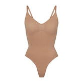 SEAMLESS SCULPT THONG BODYSUIT | SIENNA (SHAPEWEAR BODYSUITS) LAYS FLAT ON A WHITE BACKGROUND | FLT