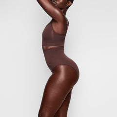 SEAMLESS SCULPT MID WAIST BRIEF WORN BY A MODEL IN SIDE VIEW