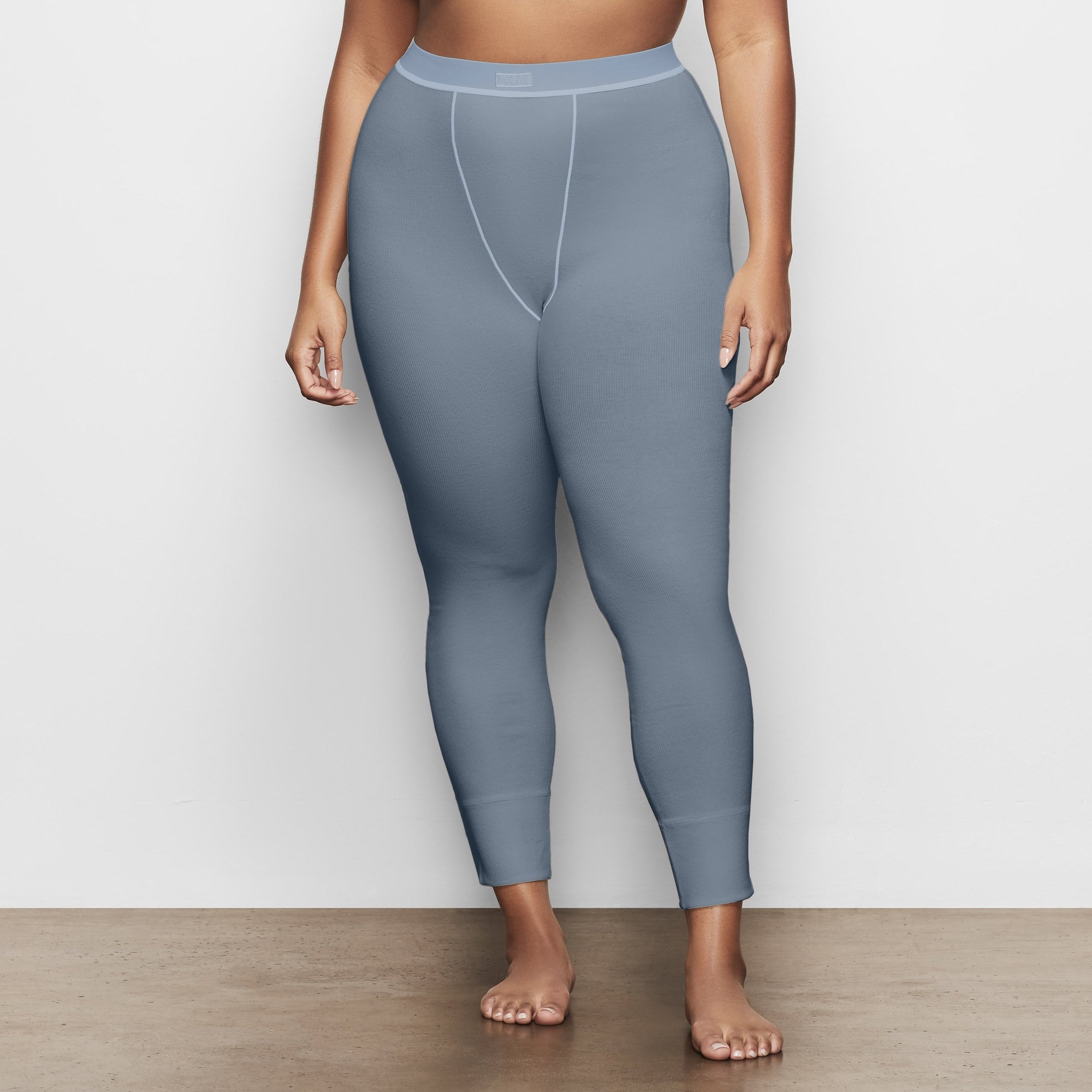 A MODEL STANDS SIDEWAYS SHOWING THE PROFILE OF THE COTTON RIB LEGGING | KYANITE