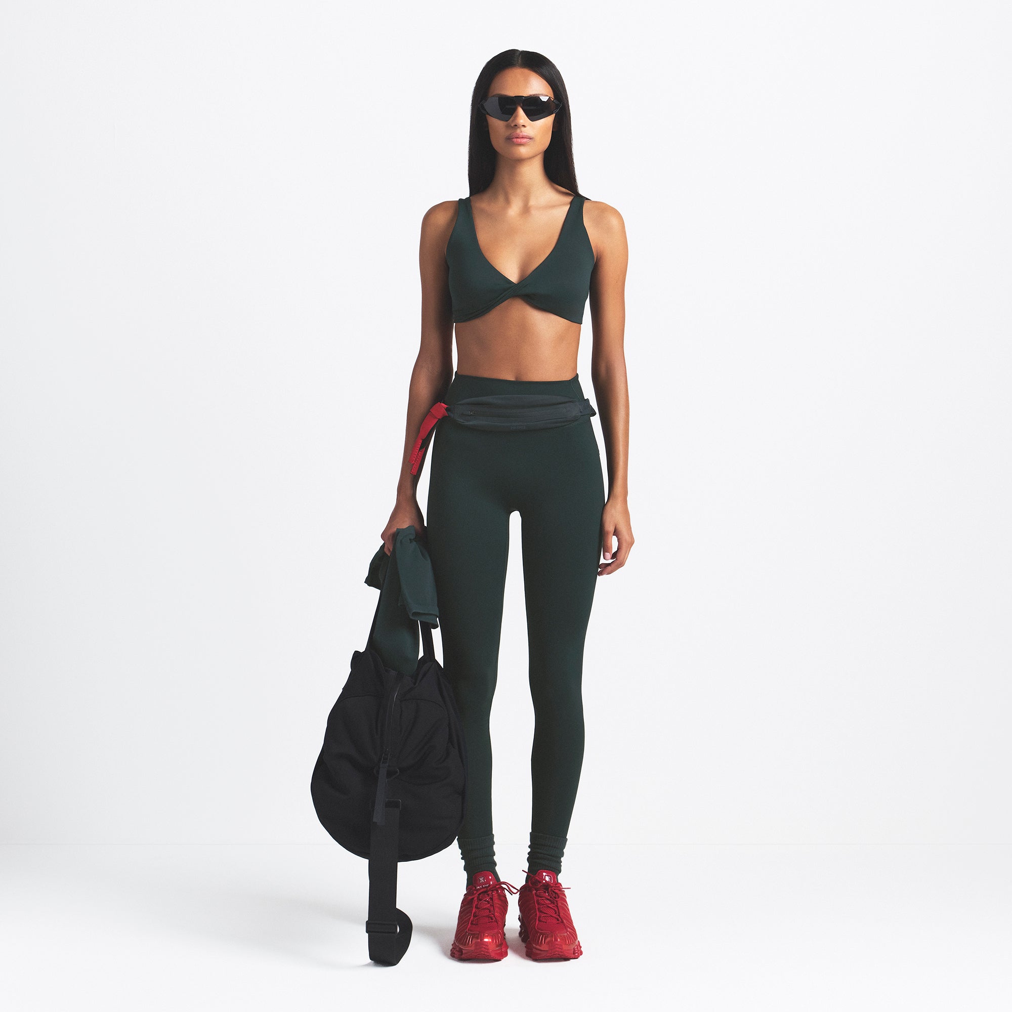 NikeSKIMS MATTE TWIST-FRONT BRA | DARK TEAL ON A MODEL FRONT VIEW @ | FOCUS: 0.0, 1.0, 0.9