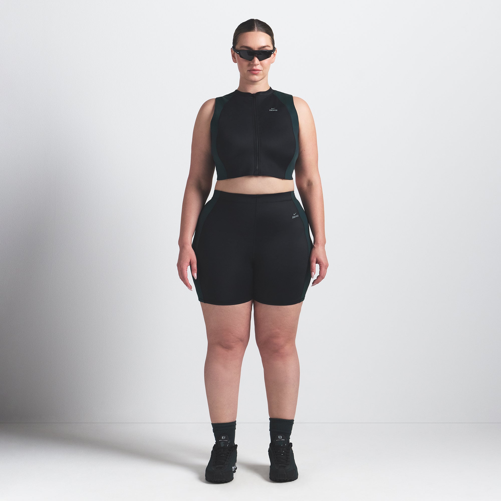 NikeSKIMS SHINE FRONT ZIP BRA | OBSIDIAN AND DARK TEAL ON A MODEL FRONT VIEW @ | FOCUS: 0.0, 1.0, 0.9
