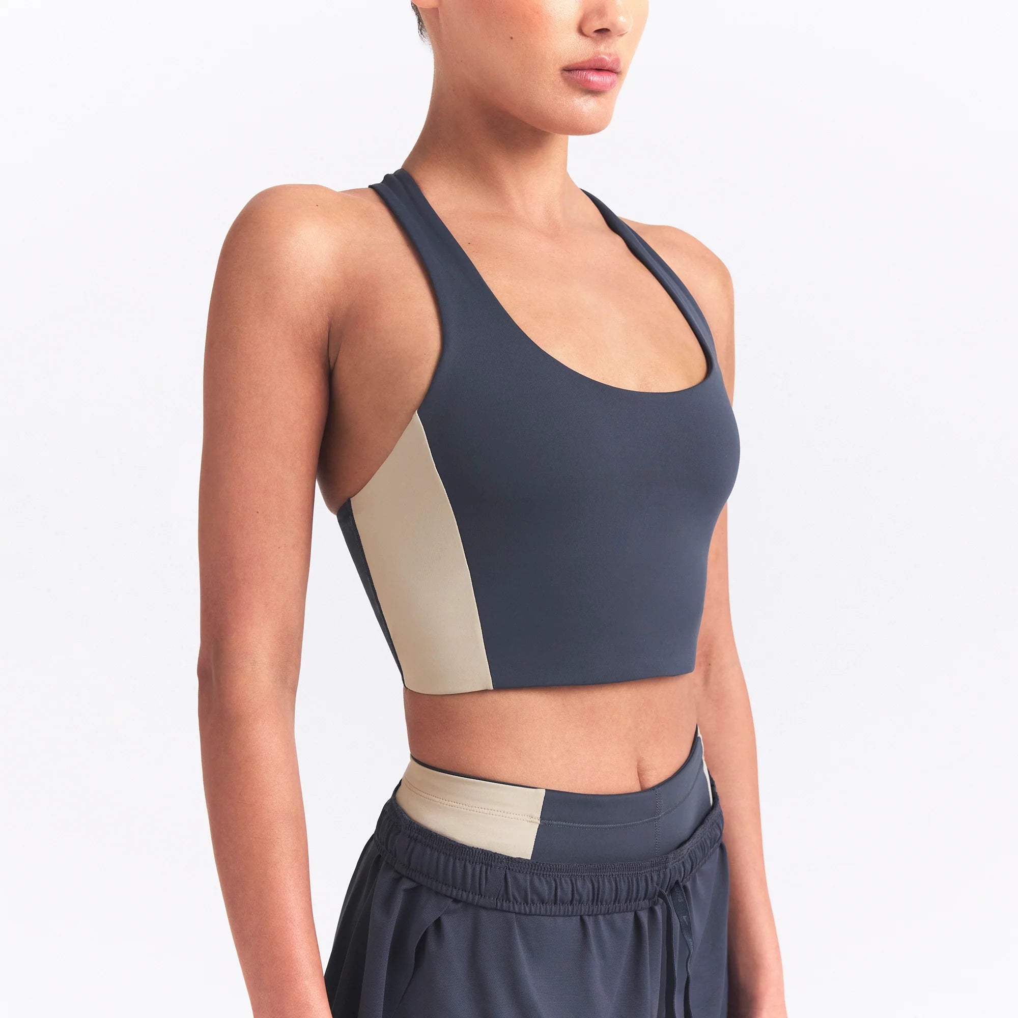 NikeSKIMS MATTE AND SHINE RACERBACK LONGLINE BRA | DEEP ROYAL/STONE ON A MODEL SIDE VIEW @ | FOCUS: 0.0, 1.0, 0.9