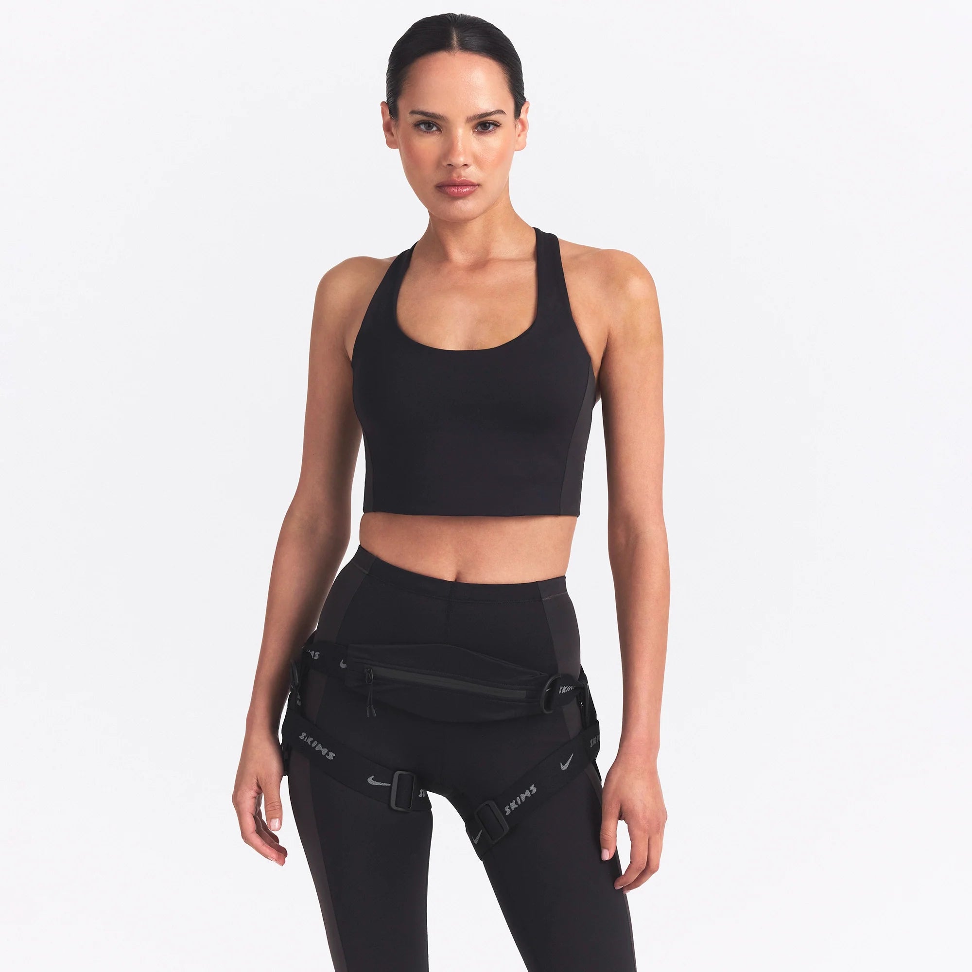 NikeSKIMS MATTE AND SHINE RACERBACK LONGLINE BRA | OBSIDIAN/IGNEOUS ON A MODEL SIDE VIEW @ | FOCUS: 0.0, 1.0, 0.9