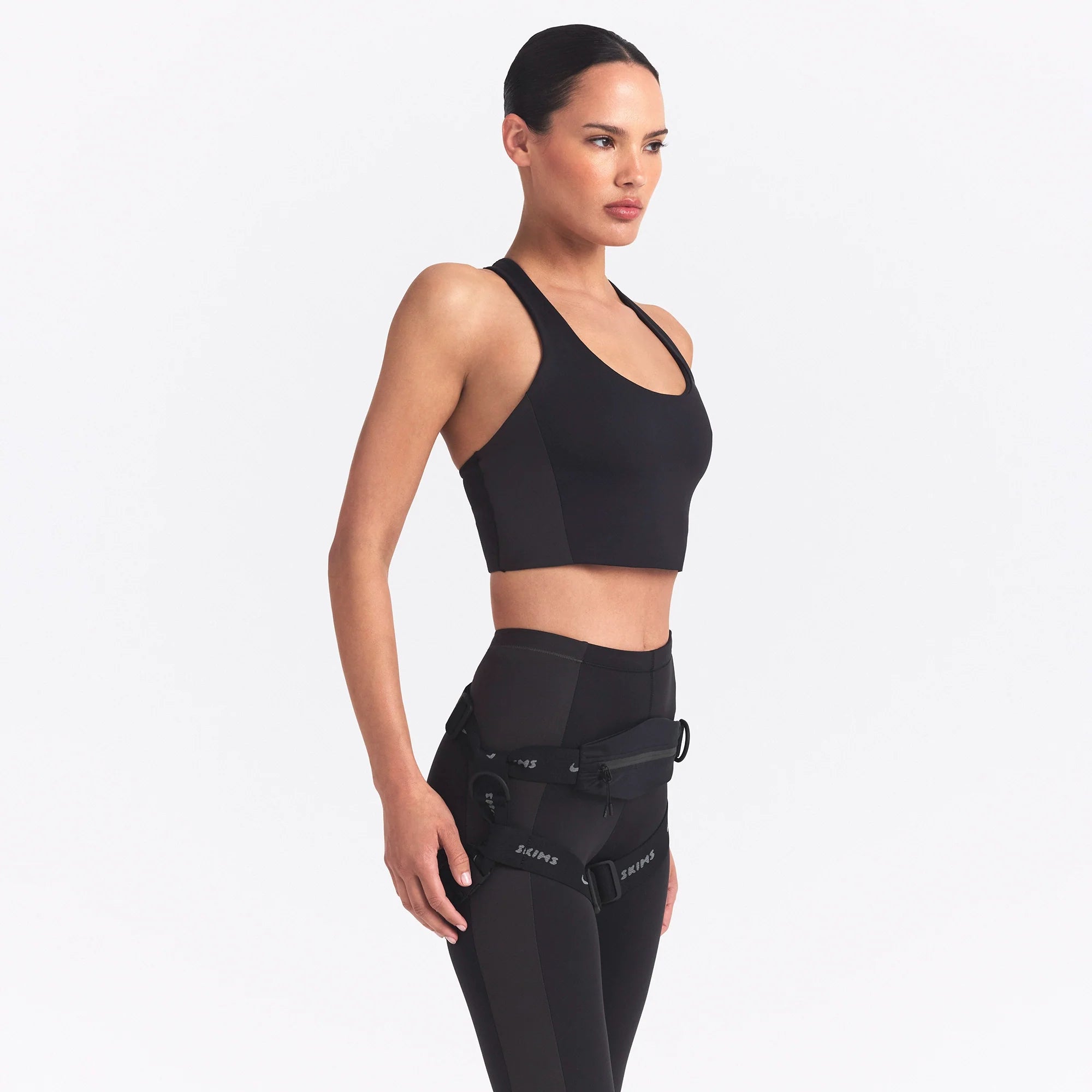 NikeSKIMS MATTE AND SHINE RACERBACK LONGLINE BRA | OBSIDIAN/IGNEOUS ON A MODEL SIDE VIEW @ | FOCUS: 0.0, 1.0, 0.9