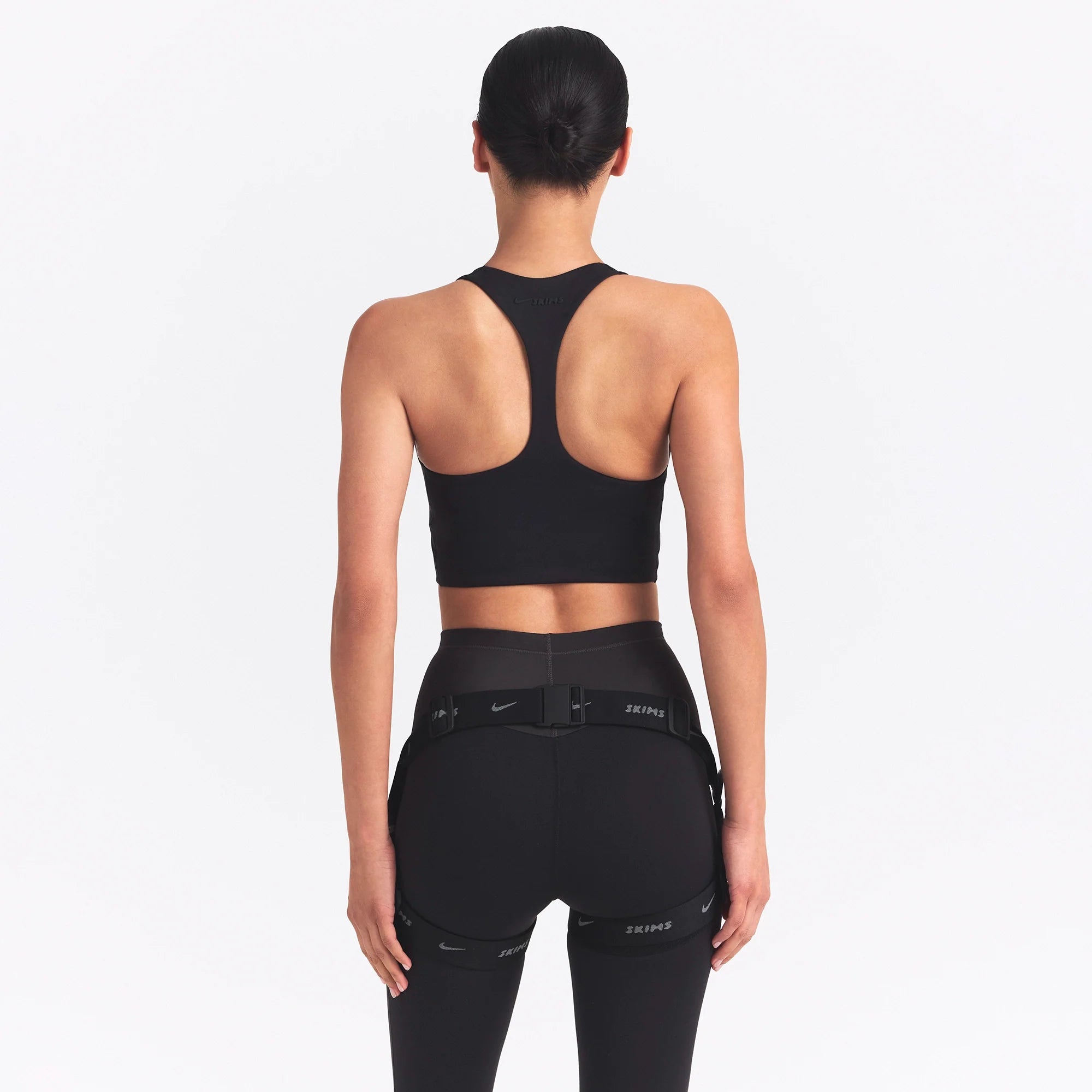 NikeSKIMS MATTE AND SHINE RACERBACK LONGLINE BRA | OBSIDIAN/IGNEOUS ON A MODEL SIDE VIEW @ | FOCUS: 0.0, 1.0, 0.9