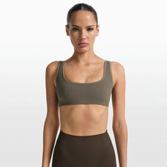 NikeSKIMS RIBBED SEAMLESS MICRO SCOOP BRA | DUSTY OAKMOSS ON A MODEL FRONT VIEW @ | FOCUS: 0.0, 1.0, 0.9