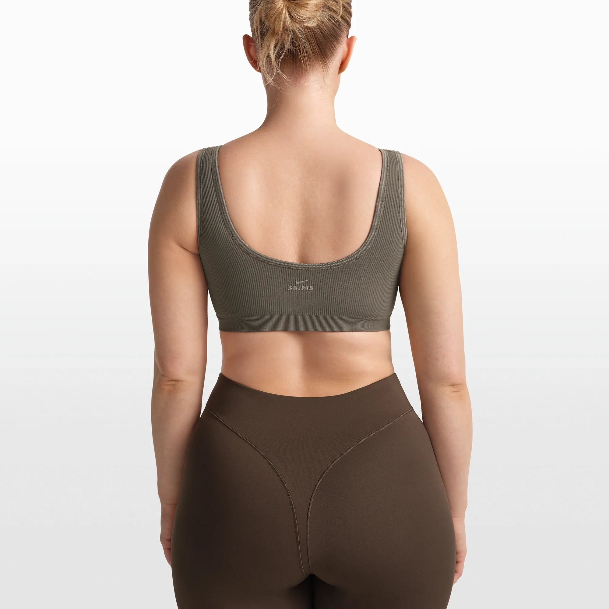 NikeSKIMS RIBBED SEAMLESS SCOOP BRA | DUSTY OAKMOSS/DUNE ON A MODEL FRONT VIEW @ | FOCUS: 0.0, 1.0, 0.9