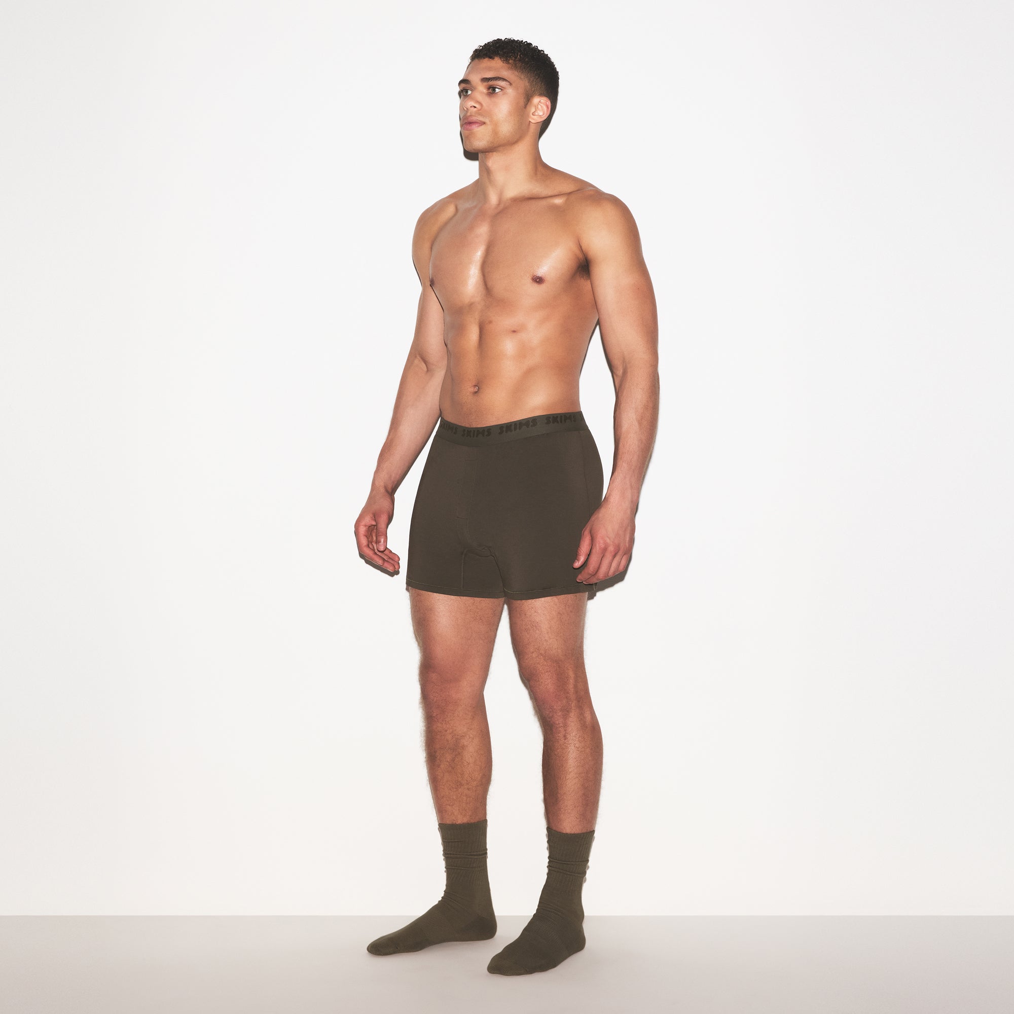 SKIMS STRETCH MENS KNIT BOXER | LODEN ON A MODEL FRONT VIEW @ | FOCUS: 0.0, 1.0, 0.9