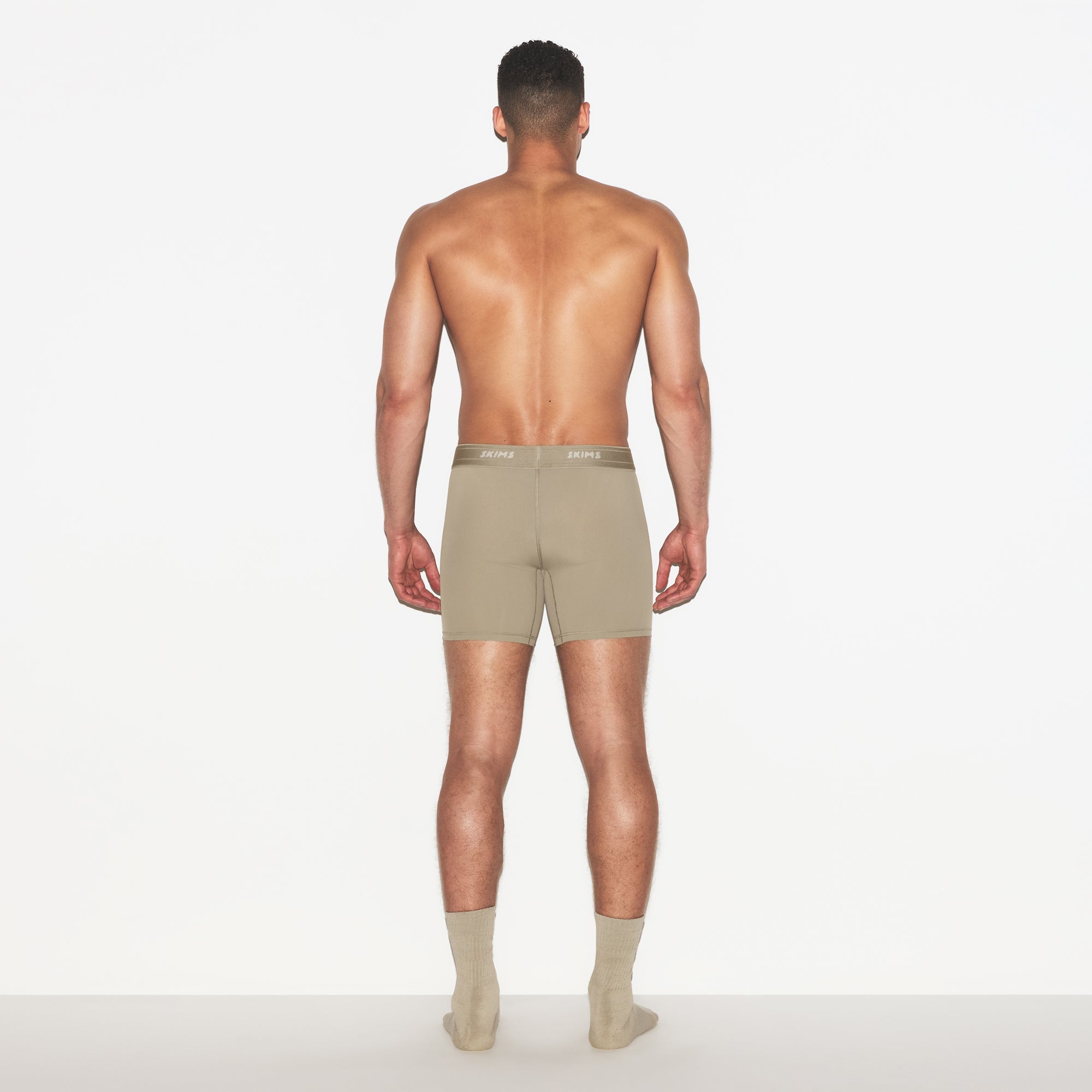 SKIMS SPORT MENS 5 INCH BOXER BRIEF 3-PACK | DUNE MULTI ON A MODEL FRONT VIEW | FOCUS: 0.0, 1.0, 0.9