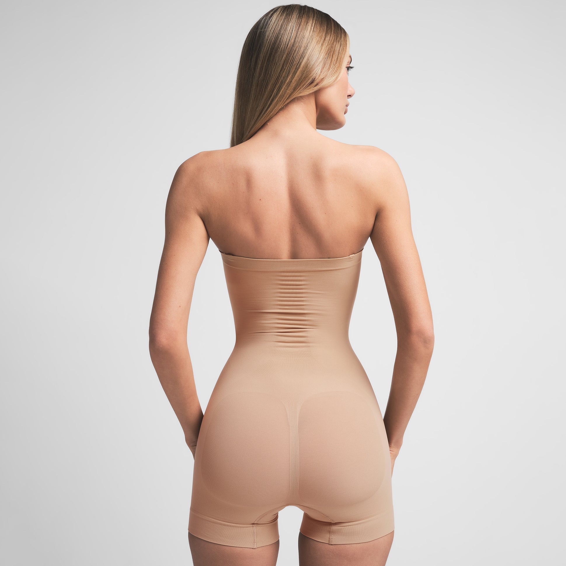 SEAMLESS SCULPT STRAPLESS SHORTIE BODYSUIT | CLAY ON A MODEL BACK VIEW