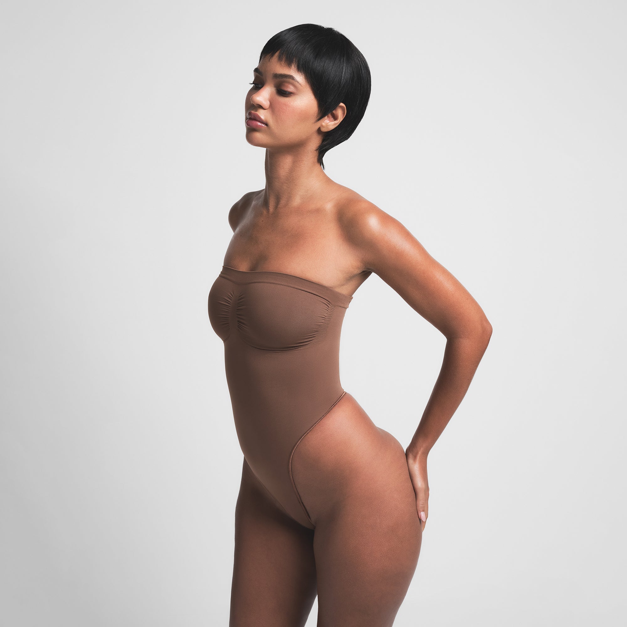 SEAMLESS SCULPT STRAPLESS THONG BODYSUIT | JASPER ON A MODEL SIDE VIEW