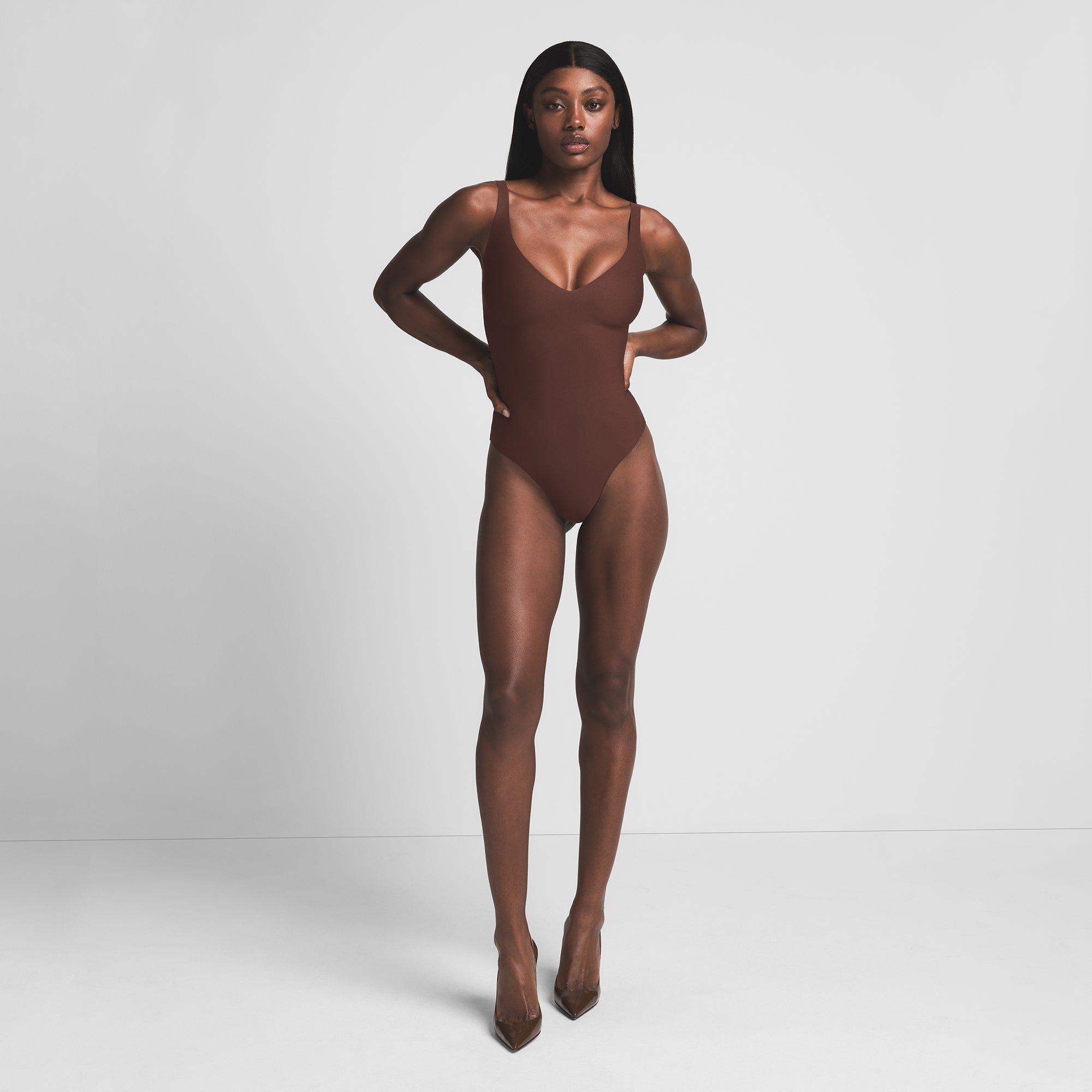 SKIMS BODY UNLINED PLUNGE THONG BODYSUIT | COCOA ON A MODEL FRONT VIEW