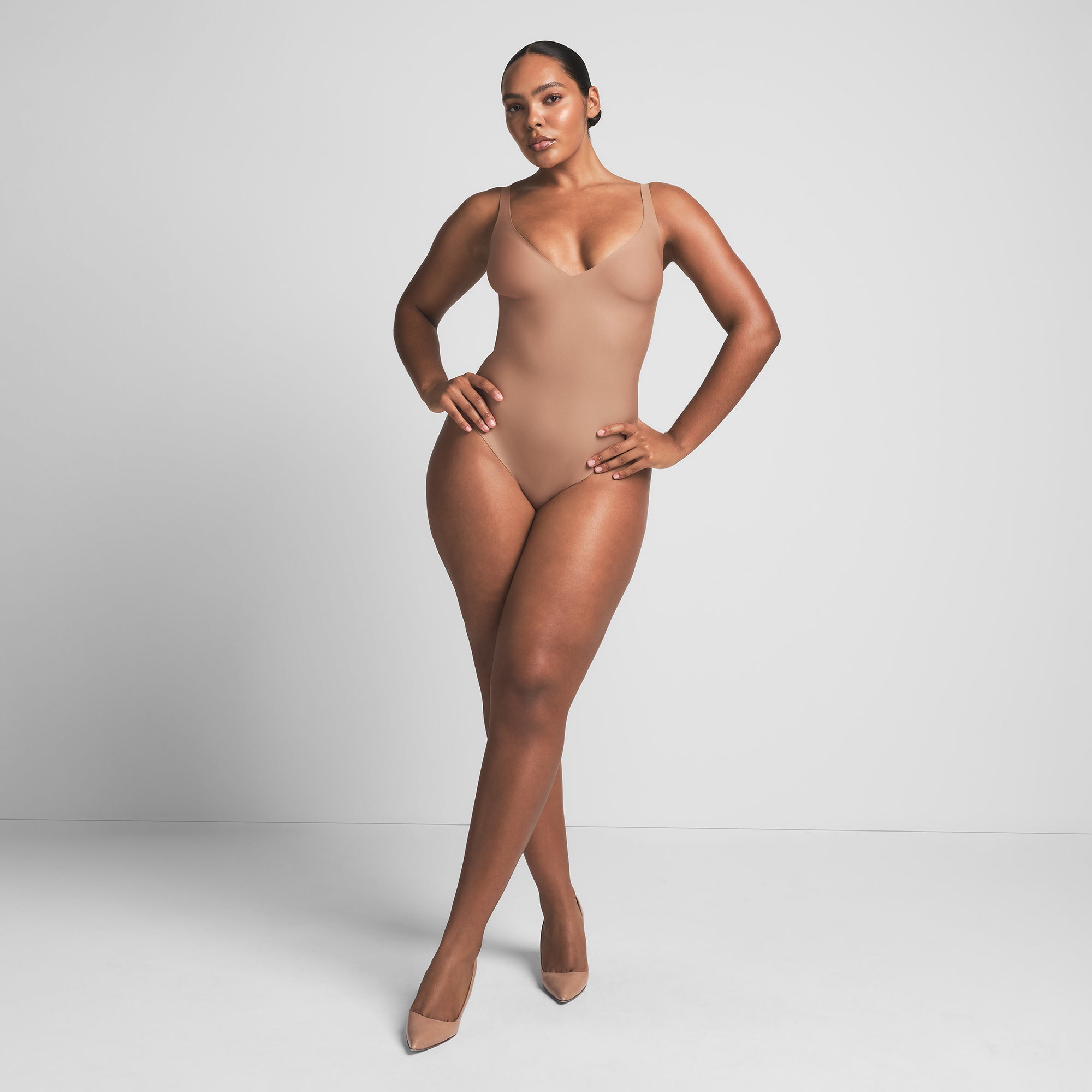 SKIMS BODY UNLINED PLUNGE THONG BODYSUIT | SIENNA ON A MODEL FRONT VIEW